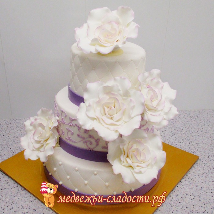 Свадебный торт в сиренево-белых тонах с большими цветами и сиреневыми узорами.